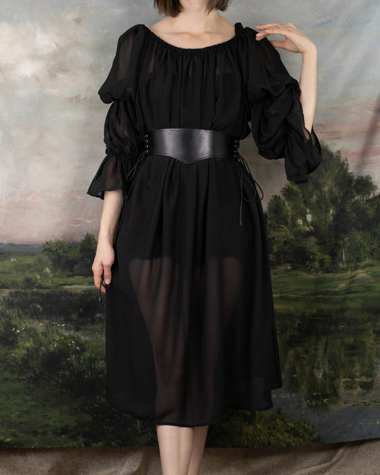 model wearing witch costume with black sheer dress and leather waist belt