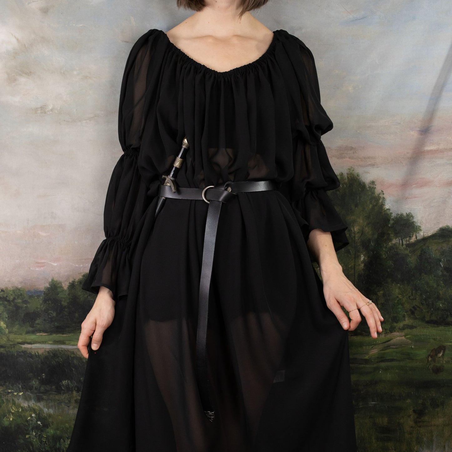 model wearing black silky dress with rouched sleeves