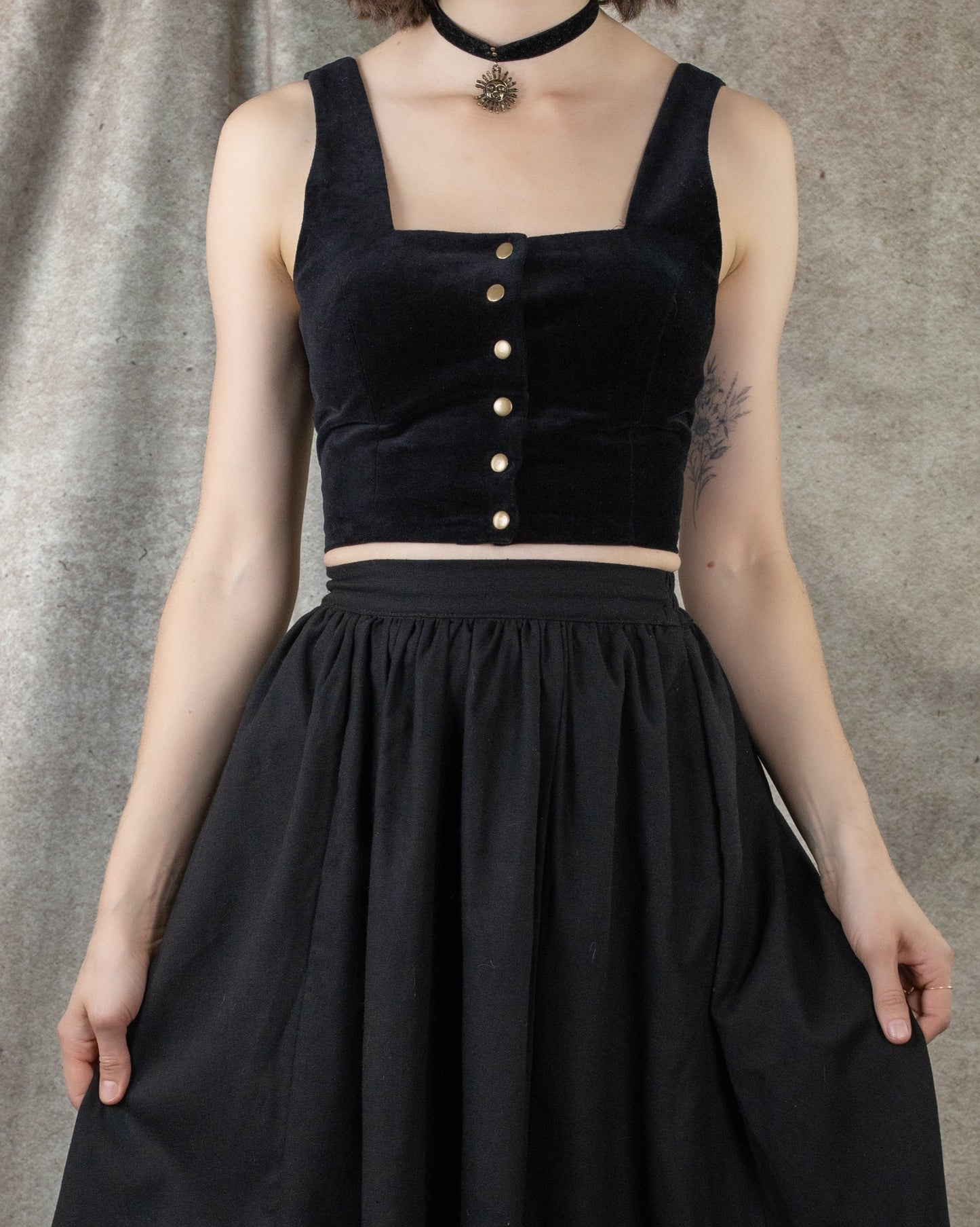 model wearing black velvet crop top with black skirt and black velvet choker necklace