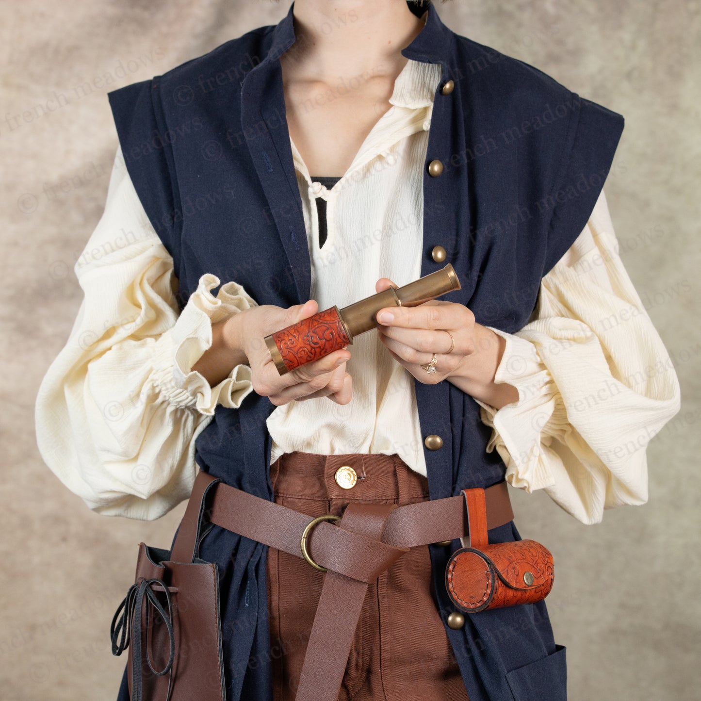 model dressed in pirate costume holding spyglass in both hands