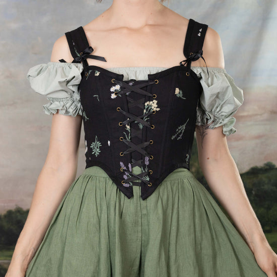 model wearing black renaissance bodice with green cotton dress and green linen skirt