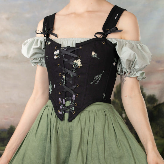 side view of model wearing black floral corset top