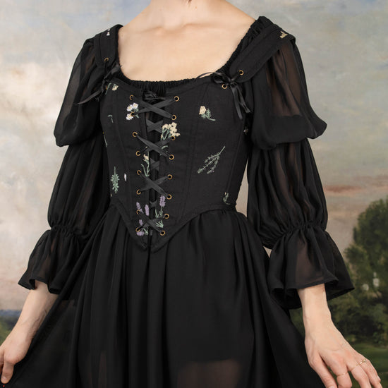 model wearing black sheer dress with black floral corset dress