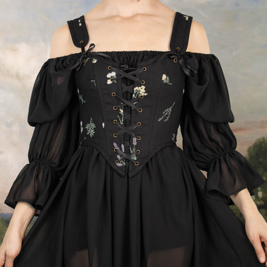 model wearing women's witch costume with black floral bodice
