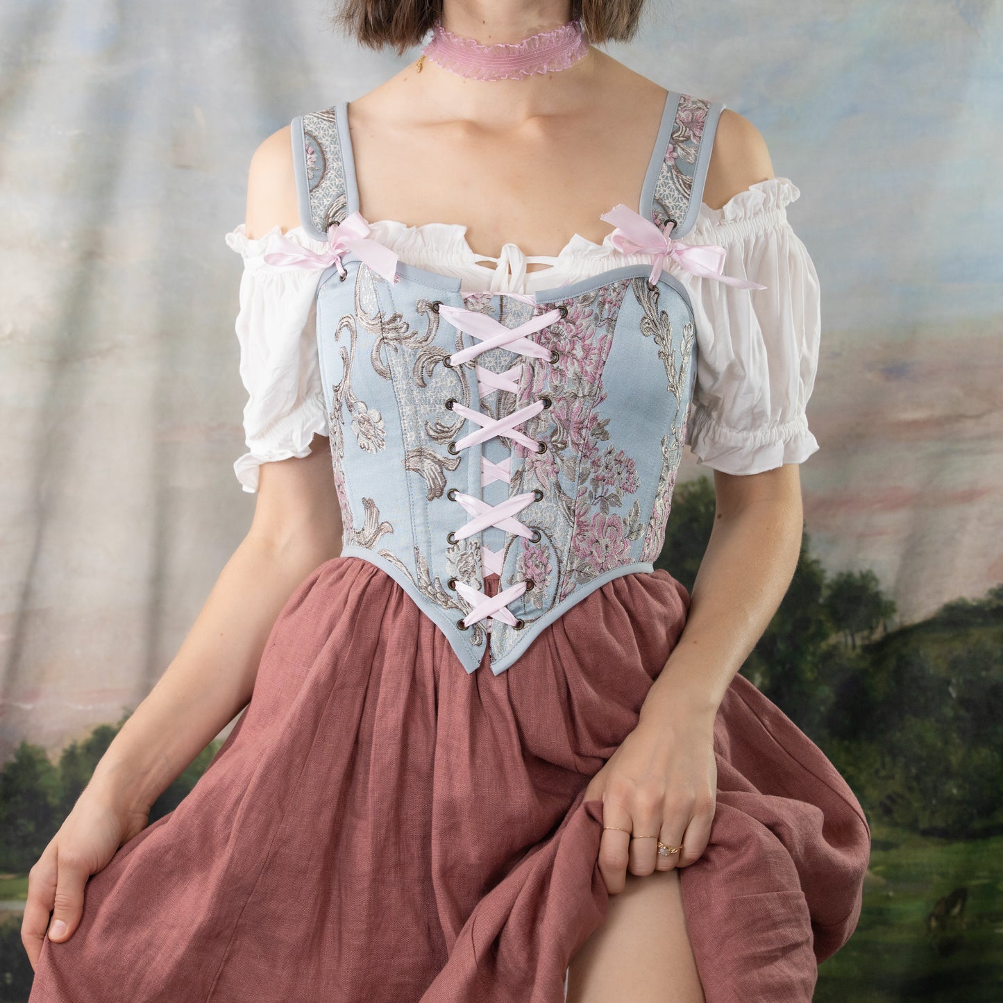 model wearing blue rococo marie antoinette corset with rose linen skirt