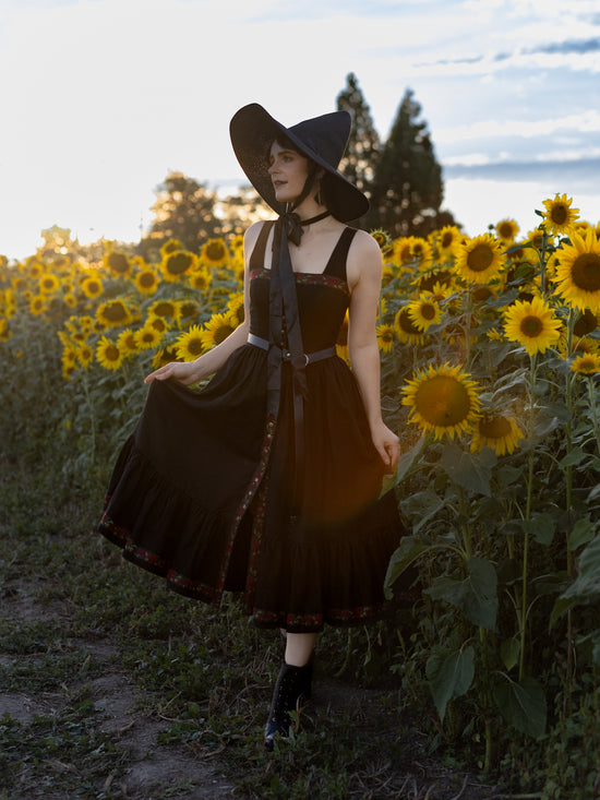 model wearing witchy dress in a sunflower field