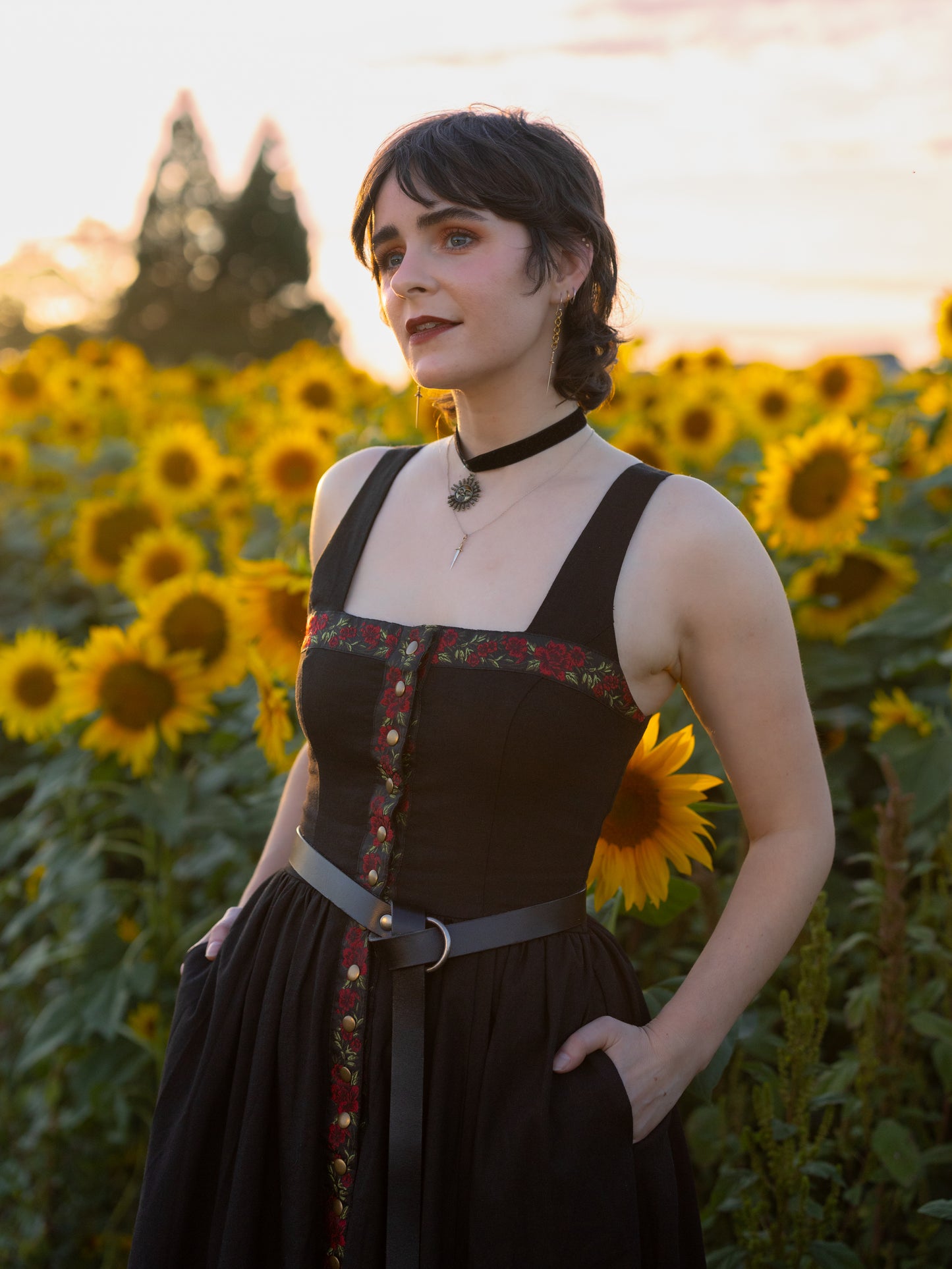 close up view of model wearing black dirndl dress with her hands in the pockets of the skirt