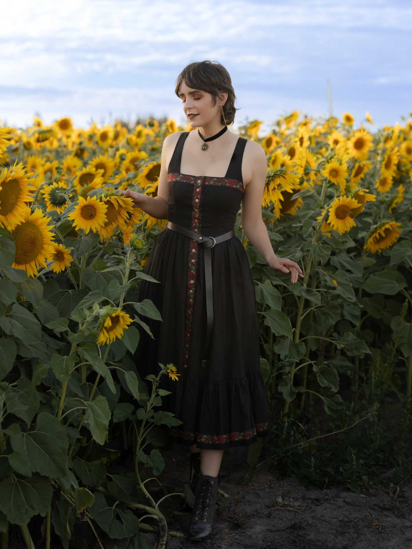 model wearing black corset sarafan dress styled with an O-ring belt